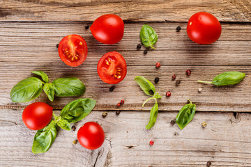 Cherry tomatoes,  basil  and pepper on wooden table, top view