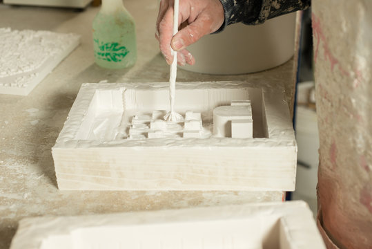 Hand Applying Dab of Plaster on Mold Using Paintbrush