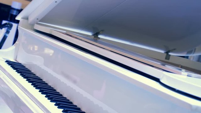 Brilliant white piano with the lid open for better sound