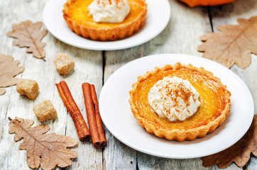 pumpkin pie decorated with whipped cream