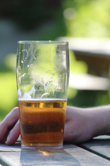 hand by half empty glass beer