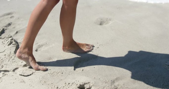 Woman walking on the beach bare footed