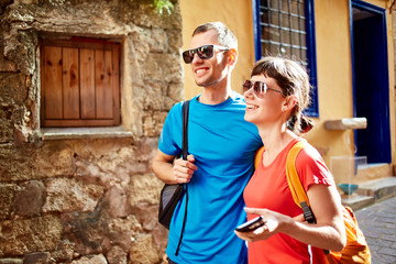 couple tourists walking in the old town. tourists considering the narrow streets of the city, happy and surprised