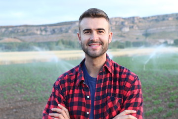 Young happy man smiling at camera in the potato and wheat fields