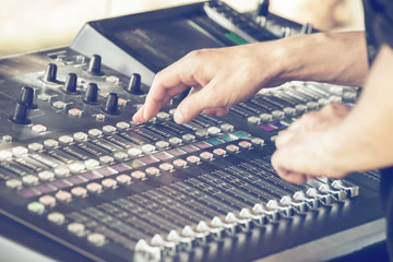 Hands adjust controls on sound mixer 2