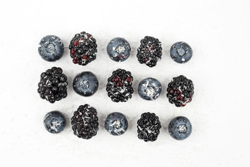 blueberries and blackberries sprinkled with coconut on white bac