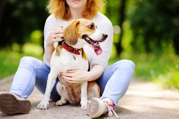 Young beautiful woman with Beagle dog in the park