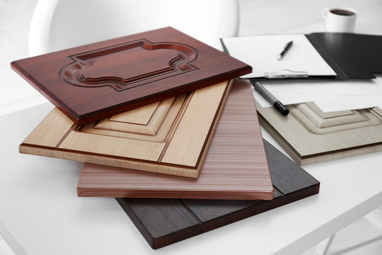 Samples of wooden panels for furniture and door on white table