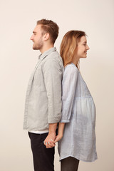 Happy family expecting baby on light background