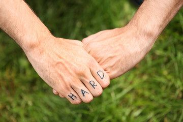 Man fist with fake tattoo on green grass background