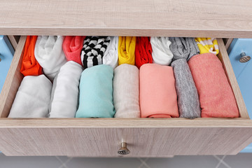Fototapeta na wymiar Neatly folded clothes in chest of drawers