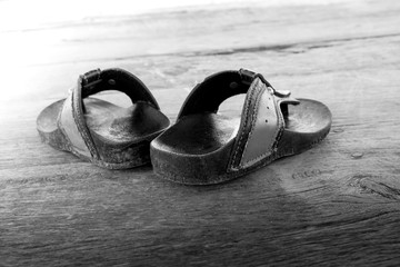 old children sandals on black and white on wooden floor