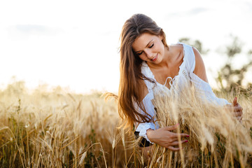 Beautiful woman hugging barley and wheat