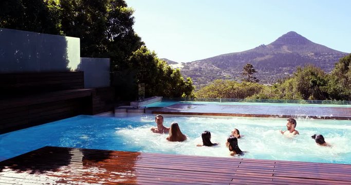 Happy friends diving into the pool in a sunny day