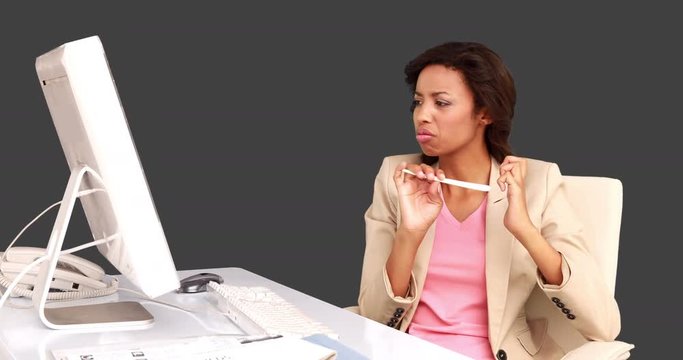 Businesswoman filing her nails at her desk on grey screen background