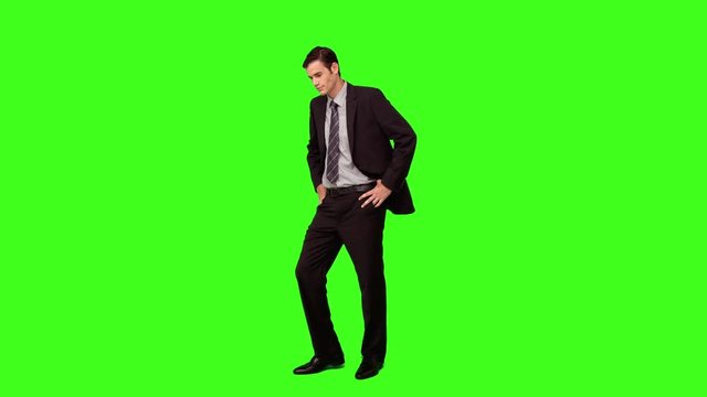 Businessman standing and looking down on green screen background