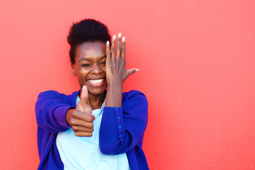 Cheerful young african woman showing thumbs up sign