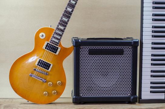 Electric guitar and amplifier isolated on a  light brown