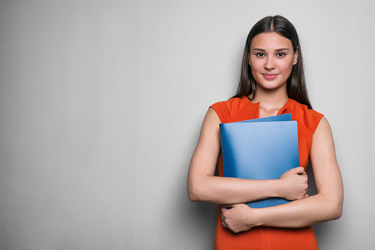 Smiling businesswoman holding folder with two hands