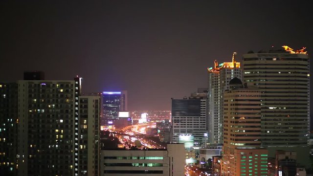 night city lights and traffic in Bangkok as abstract background. Out of focus with blurry car and business building light, bird eyes high angle view