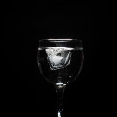 Glass with water on black background