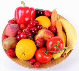Fresh fruits and vegetables on wooden plate