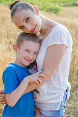 Fototapeta premium Mother and son hugging in wheat field