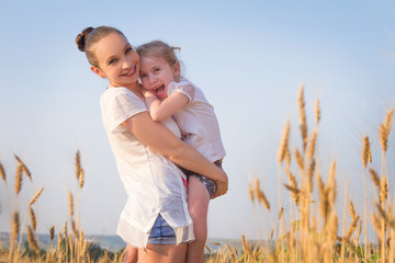 Fototapeta premium Happy mother and daughter in wheat field