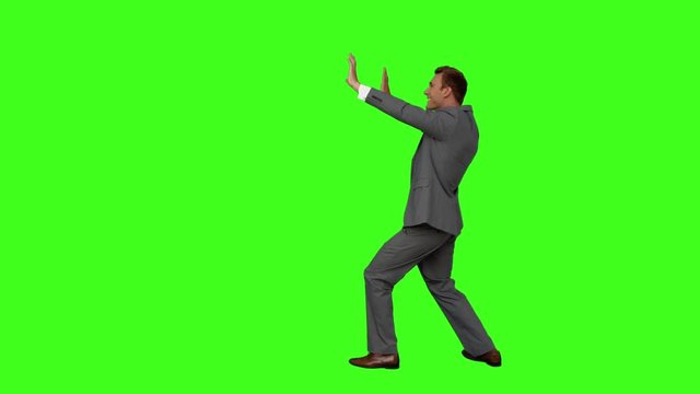 Businessman standing and pushing on green screen background