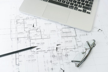 black pencil and computer laptop on architectural drawing paper for construction
