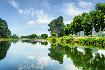 Fototapeta premium Amazing natural karst towers and green trees reflected in water