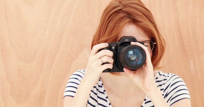 Smiling hipster woman taking picture with digital camera 