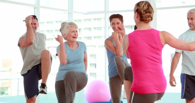 Aerobics class stepping and laughing together