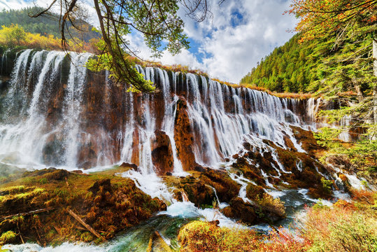 The Nuo Ri Lang Waterfall (Nuorilang) among fall forest