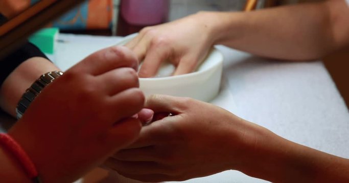 Nail technician giving customer a manicure at the nail salon