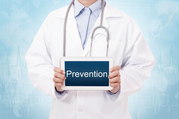Doctor holding a tablet pc with prevention sign on blue background