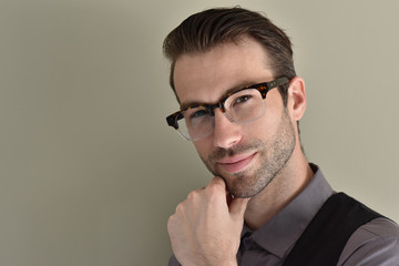 Obraz premium Stylish guy with eyeglasses on beige background