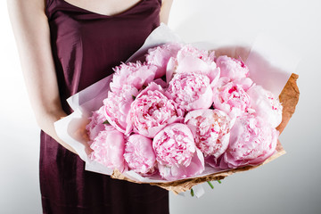 fresh bright blooming peonies flowers with dew drops on petals. white and pink bud. kraft paper. crisp packaging