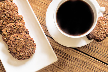 Oatmeal cookies and coffee on the wooden table