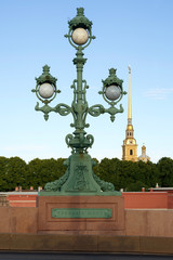 Fototapeta na wymiar Lantern Trinity Bridge on background the spire of the Peter and Paul Fortress. The inscription 