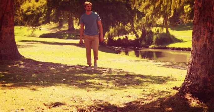 Handsome man walking in the park and holding retro photo camera