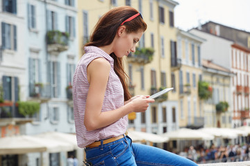 Young female tourist is searching way in navigation on touch pad