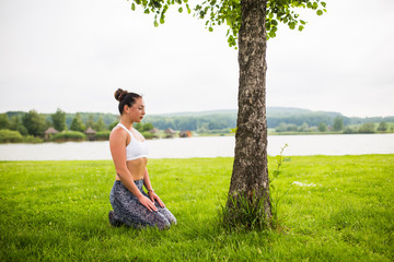 virasana. Yoga girl training outdoors on nature background. Yoga concept.