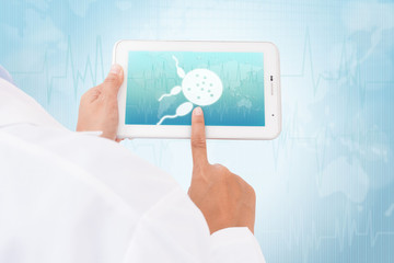 Doctor hand touch screen Spermatozoon symbol on a tablet. medical icon