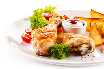 Grilled chicken legs with baked potatoes and vegetables 