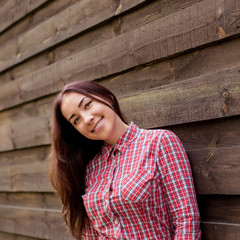 Gorgeous brunette hipster smiling against wooden planks