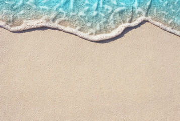 Soft ocean wave on the sandy beach, background. - obrazy, fototapety, plakaty