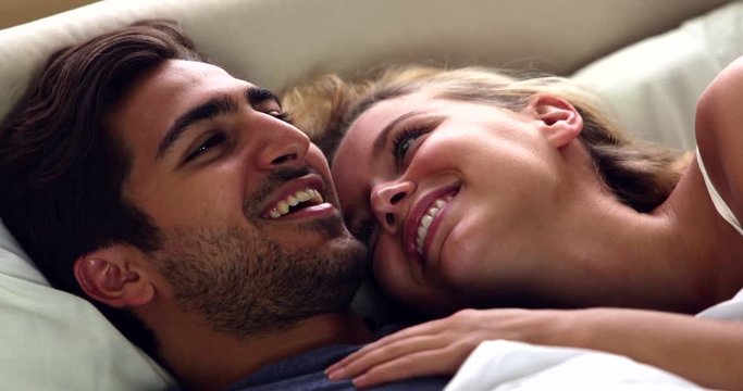 Cute couple laughing in bed