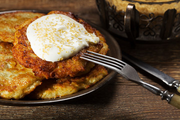 Homemade potato pancakes served with sour cream and brown sugar