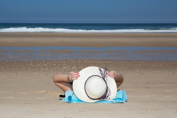 Fototapeta na wymiar girl lies on the white sand on the beach